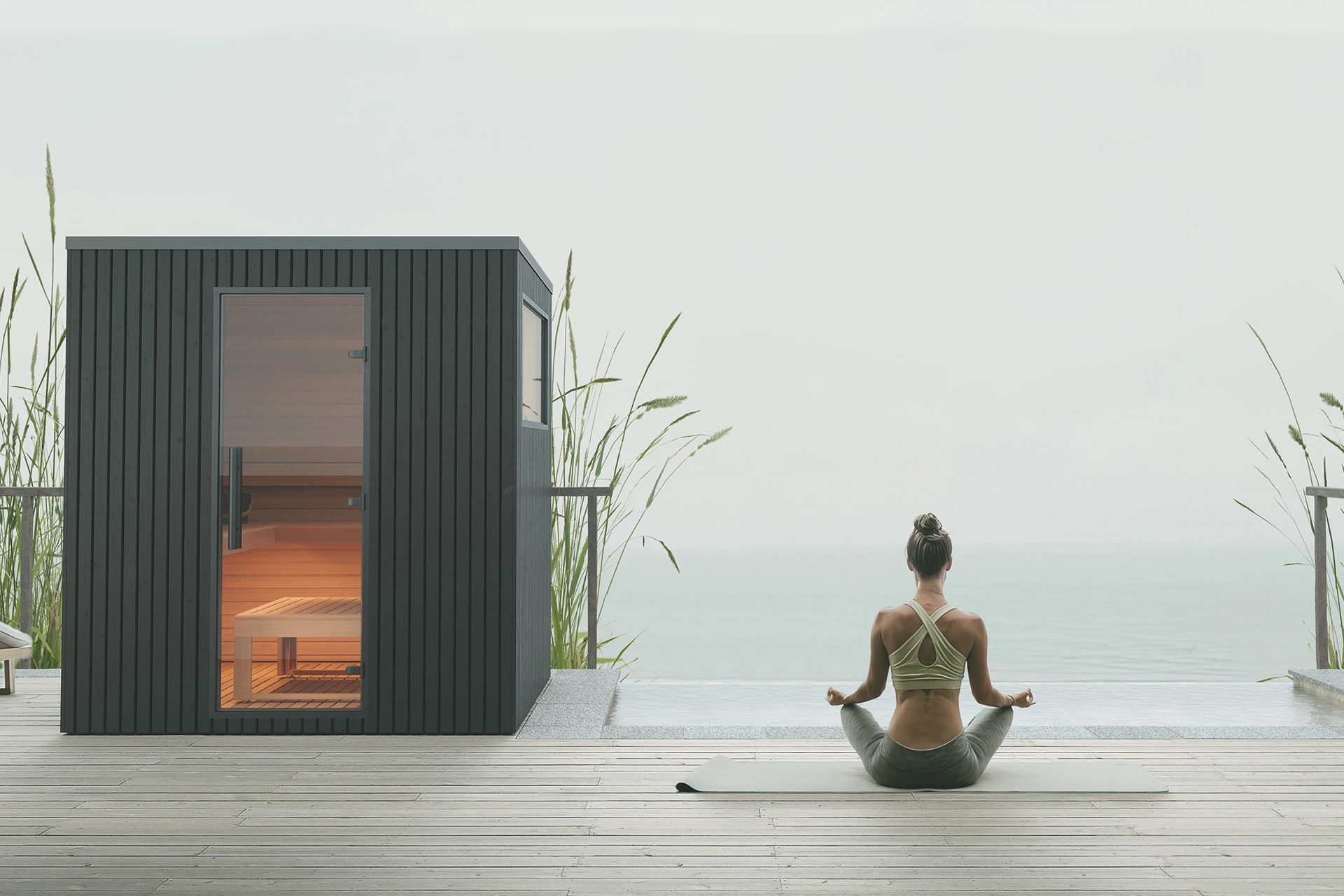 Black Garda sauna with a glazed door and high side window beside water